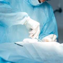 surgeon-performing-surgery-breasts-hospital-operating-room-surgeon-mask-wearing-surgical-loupes-during-medical-procedure